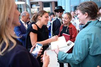 Cleo Wade stops in a crowd to sign a book.