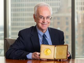 Dr. Lee Hamm holds open a velvet case with the Nobel Prize - a gold medal inside