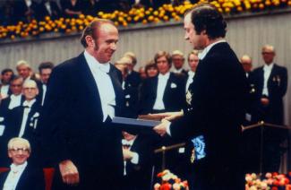 1977 photo of Dr. Andrew Schally, in a tuxedo, receiving the Nobel Prize before an audience