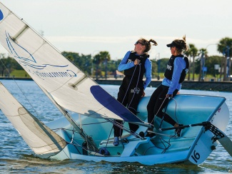 two women operate a sailboat