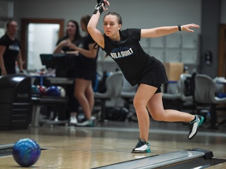 Sofiia Druchyna releases a bowling ball in a bowling alley