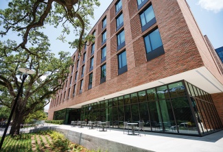 River and Lake brick buildings with oak trees and sidewalk tables