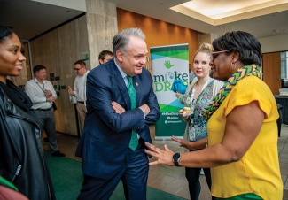 President Fitts talks with three women in the lobby of the Tidewater building