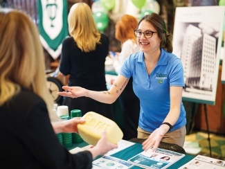 a woman talks to a visitor to an information table