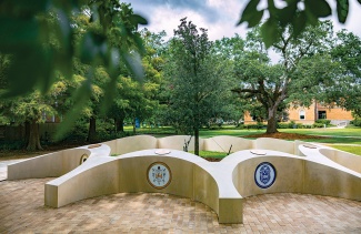 sculptural monument of nine plots nestled among trees 
