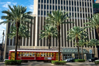 A streetcar passes in front of the Tulane University School of Public Health and Tropical Medicine as it rolls down Canal Street 