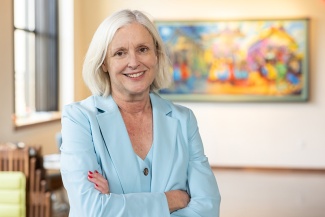 Susan Davies standing in a light blue suit