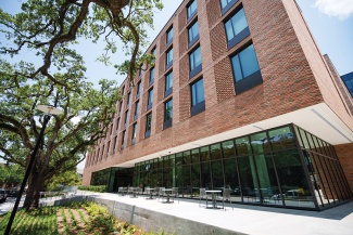 exterior of brick building with oak tree and sidewalk