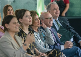 Leslie and Paul Lux sit with President Michael A. Fitts in the audience for a dedication ceremony