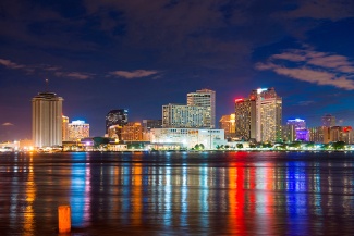 New Orleans skyline at night with light reflections on the river