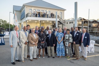 group photo of attendees of the dedication in front of the Alexander Community Sailing Center building