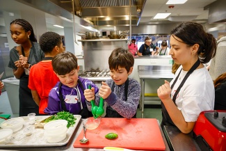 A group of kids learning to cook in a kitchen