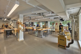 Students work in Richardson Memorial Hall's expanded Fabrication Labs. The light-filled room houses saws, hand and power tools, and large work tables. 
