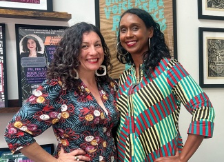 Stephanie Porras and Mia L. Bagneris smile and pose wearing brightly colored patterned clothing