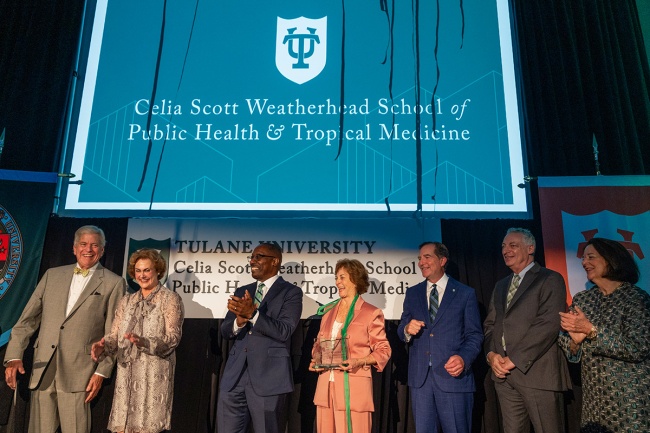 celebration attendees on stage at celebration of school renaming with blue banner