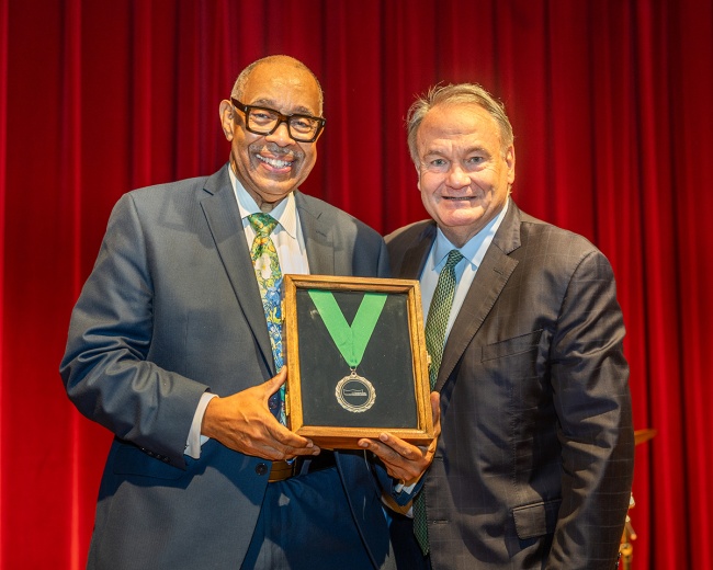 Dr. Michael White receives the Tulane Trailblazer medal from President Michael A. Fitts