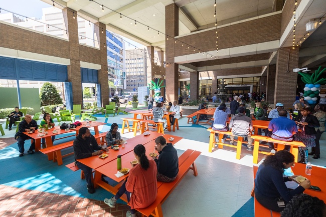 people eating at picnic tables at an open air food court